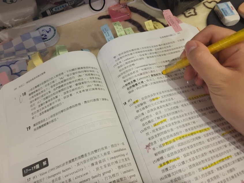 學生利用助學金，購買教師檢定考試用書，並進行學習。